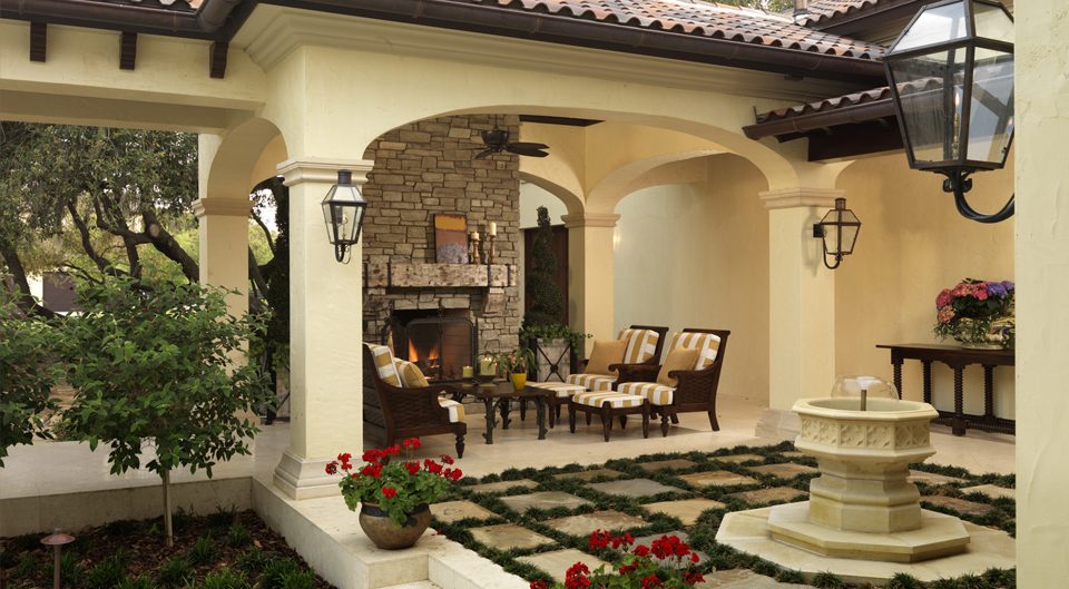 Courtyard loggia with a stone fireplace, lanterns and a small fountain