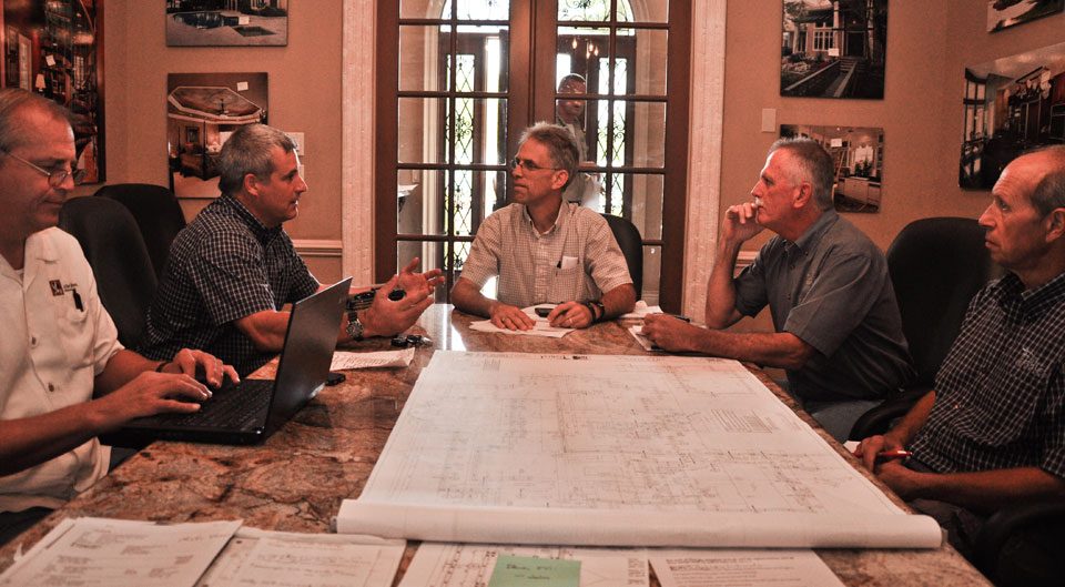Fechtel team members reviewing house plans around a conference table